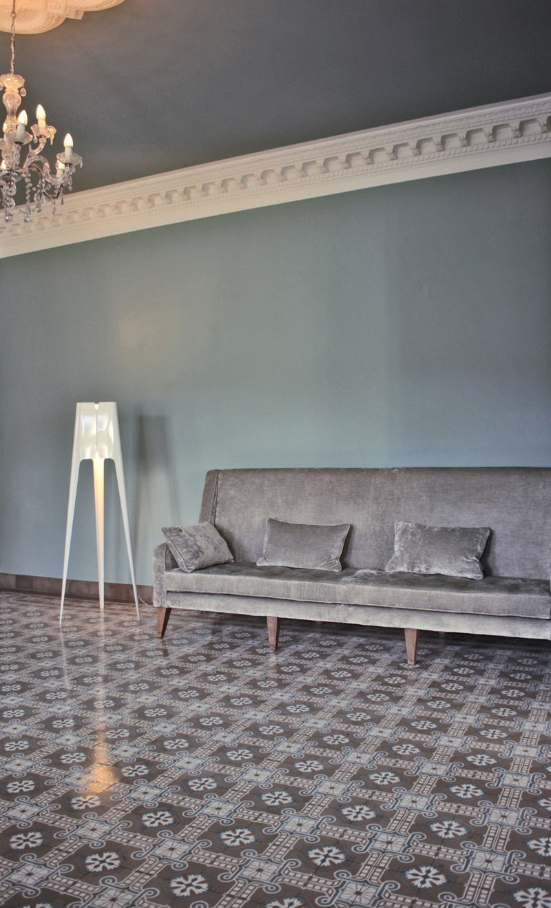 Zementmosaikplatten mit einer grauer Wand und einer Couch